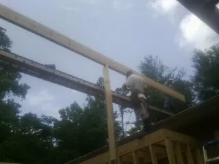 Carpenter setting a ridge beam over a new addition frame — Ice Dam Removal by Roofing Brothers in Enoree