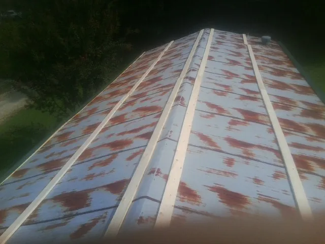 Rusted metal roof panels with new wood purlins before replacement — Storm Damage Roof Repair in Enoree by Roofing Brothers