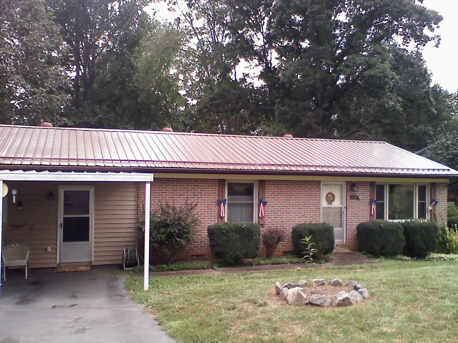 Bronze metal roof and carport on a brick ranch home — Roof Repair work by our crew in Enoree